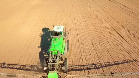 Tractor spraying a field with sprayer, herbicides and pesticides at sunset. Stock Footage 154279014
