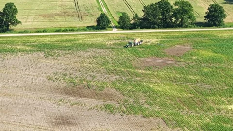A tractor sprays a parched field Video stock 315213506