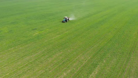Tractor sprays solid fertilizer in the field, agriculture and agribusiness Stock Footage 132230762