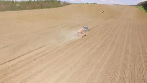 Tractor spreading artificial fertilizers in field. Top view, aerial shooting Stock Footage 211807386