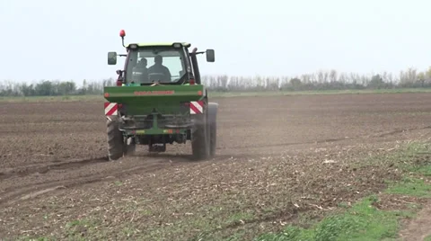 Tractor spreading fertilizer in springtime under a blue sky Video stock 37046098