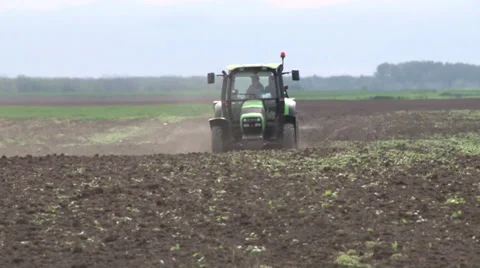 Tractor spreading fertilizer in springtime under a blue sky Video stock 37048221