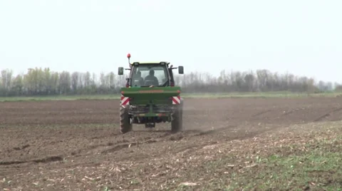 Tractor spreading fertilizer in springtime under a blue sky Video stock 37048444