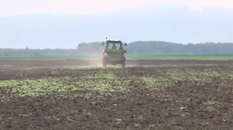 Tractor spreading fertilizer in springtime under a blue sky Vidéo 37050011