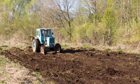 Tractor on a spring field Stock Photos