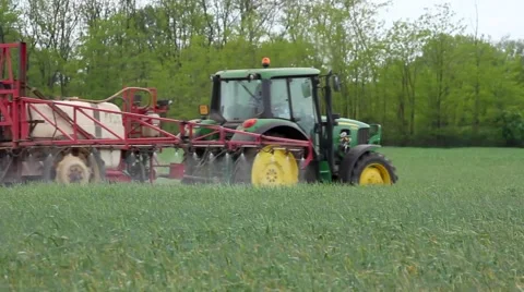 Tractor sprinkling plants on the field Stock Footage 54026660