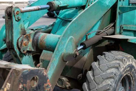 A tractor stands ready for work, its details visible under the sun on a far.. Stock Photos