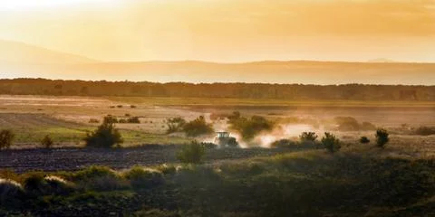 Tractor at sunset Stock Photos