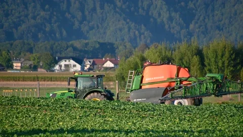 Tractor with a super trailed sprayer with tank in a farming field Stock Footage 226343010