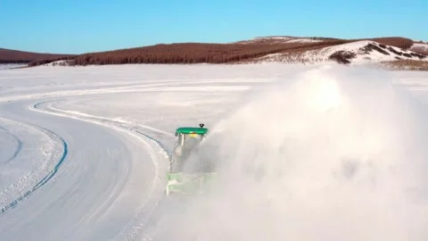 Tractor Throwing a Towering Snow Plume Beside a Winter Track Stock Footage 344955371