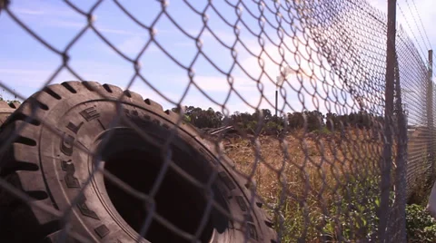 Tractor tire and mill through fence Stock Footage 39566137