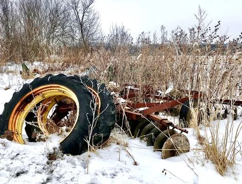 Tractor tires and Feild plow on a snowy terrain Stock Photos