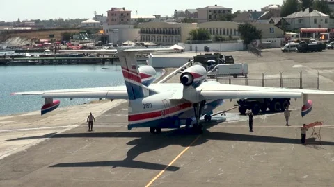 Tractor tows Be-200ES amphibious aircraft along airfield to parking lot. Stock Footage 134465319