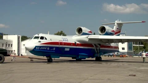 Tractor tows Be-200ES multipurpose amphibious aircraft at airfield. Stock Footage 132980053