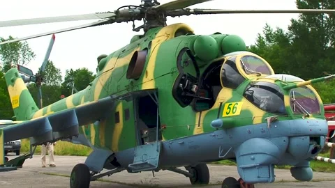 Tractor tows helicopter Mi-24 / Mi-35 (NATO: Hind) in direction of helipad. Video stock 130197441