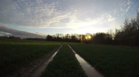 Tractor tracks going through the field and sunrise, time lapse 4K Stock Footage 62503878