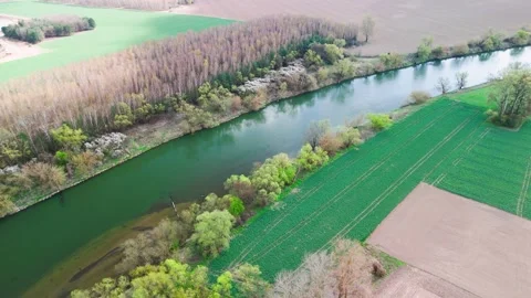 Tractor tracks run in straight lines across a vivid green field beside slow Stock Footage 347017430