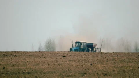 A tractor with a trailed seed drill working in the field. Planting of crops 스톡 동영상 109484531