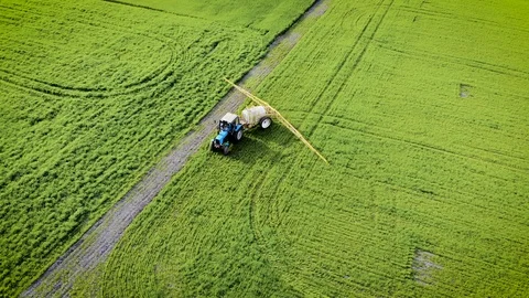 Tractor with trailed sprayer starts processing field and include watering with Stock Footage 107941642