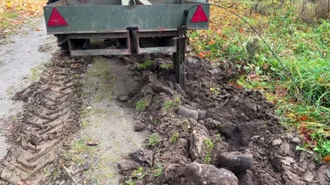 Tractor trailer attachment plowing soil, loosening ground for infrastructure Stock Footage 337072098