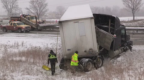Tractor trailer crash on icy snow covered highway in winter storm Stock Footage 44990551