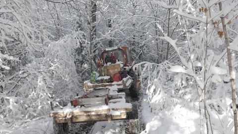 Tractor with trailer driving down trail in winter snow covered trees, 4k Stock Footage 120314572