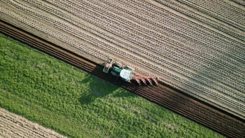 Tractor with trailer plowing field in spring, top drone view Stock Footage 341122280
