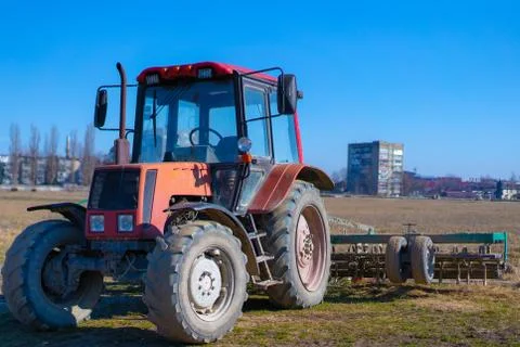 Tractor with a trailer plows a field Stock Photos