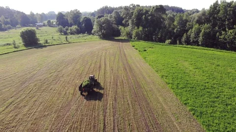 Tractor With Trailer Removes Mowed Grass From The Field Stock Footage 128076765