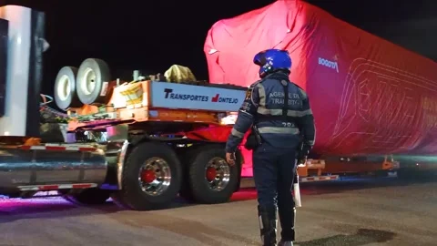 A tractor-trailer is transporting the first train car in Bogotá Stock Footage 316834779