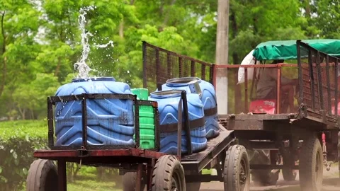 Tractor Transporting Water Tanks Through a Tea Plantation Stock Footage 341675376