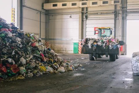 Tractor transports garbage at the plant for processing and sorting waste. Rai Stock Photos