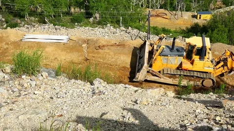 Tractor truck on tracks pulls a house on skids on sandy road Stock Footage 73137067