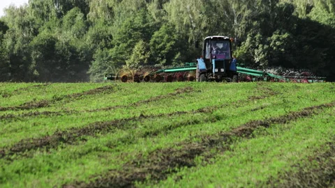 Tractor turns hay with a rake to dry Stock Footage 146505942