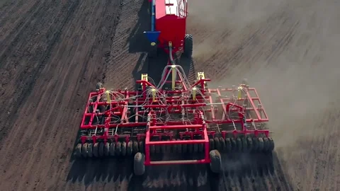 A tractor using agricultural machinery sows a field. Automation of production 库存影片 134741609