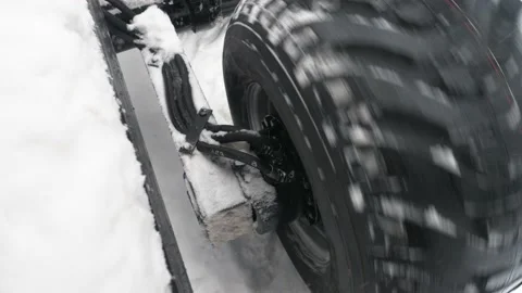 Tractor wheel slides on snow close-up at an angle Stock Footage 169548654