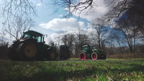 Tractor wheels struggle to rescue stuck lorry from muddy farm field Stock Footage 306380678