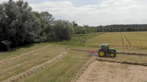 Tractor windrowing a field on a farm Stock Footage 112981780