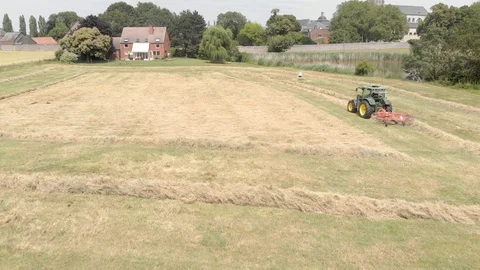 Tractor windrowing a field  Stock Footage 112980227