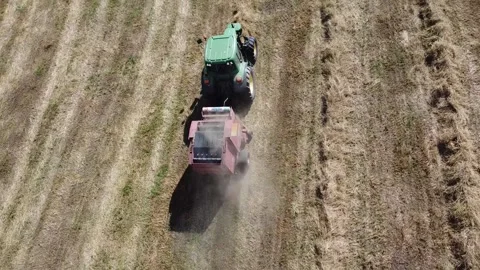 Tractor at work producing round bales of hay Stock-Footage 130982482