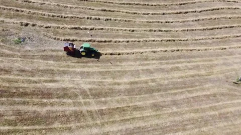 Tractor at work producing round bales of hay Vídeo Stock 130982514