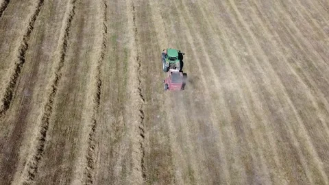 Tractor at work producing round bales of hay Stock Footage 130982850