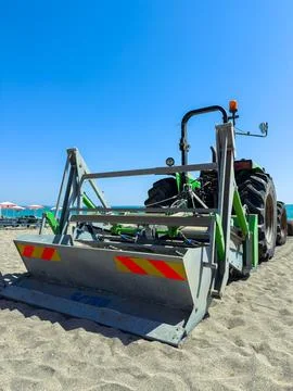 Tractor working on the beach to maintain sand and prepare the area for visito Stock Photos