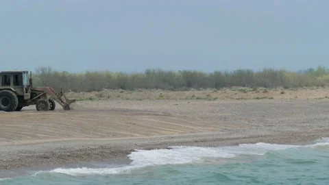 Tractor Working On The Empty Beach Leveling Beach Video stock 135376197