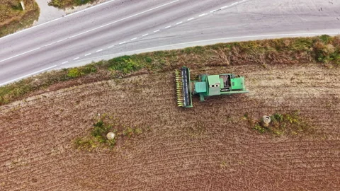Tractor working on a field beside a road during daytime Stock Footage 345454882