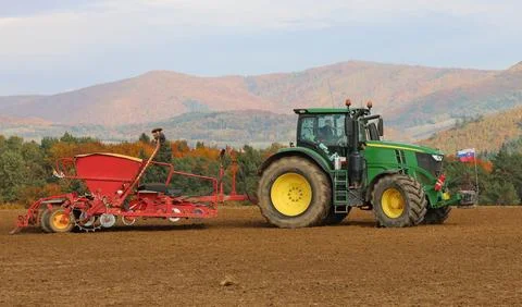 Tractor working in the field with a seed drill Stock Photos