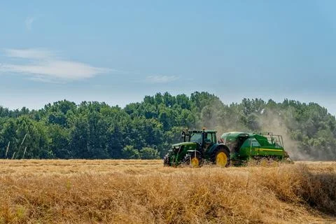 Tractor working on fields harvesting crop Stock Photos