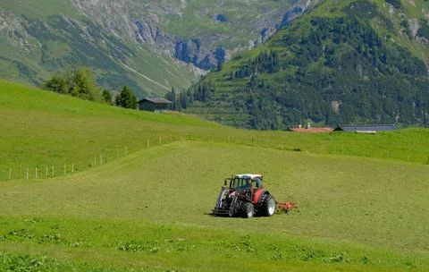 A tractor working in the fields high in the mountains Stock Photos
