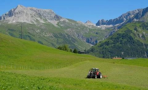 A tractor working in the fields high in the mountains Stock Photos