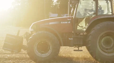 Tractor working in the grain fields in slow motion - lens flare and sunset 動画素材 40243109